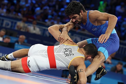 Darian Toi Cruz (red)  and Aman Sehrawat of India in action